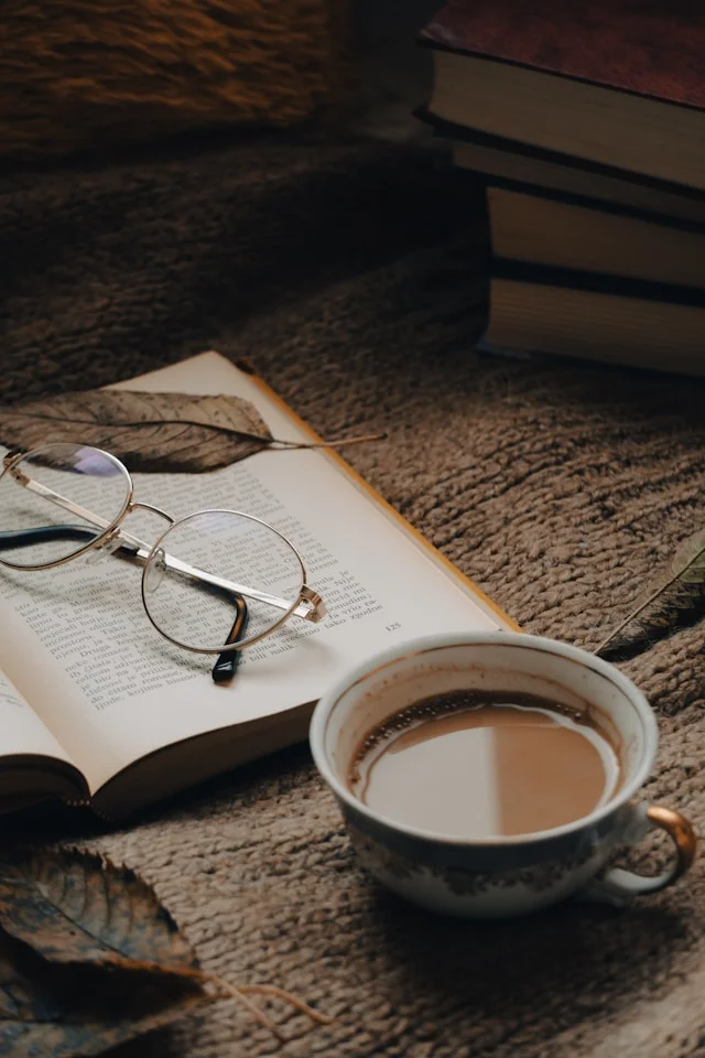 Lentes sobre libro y una taza de cafe